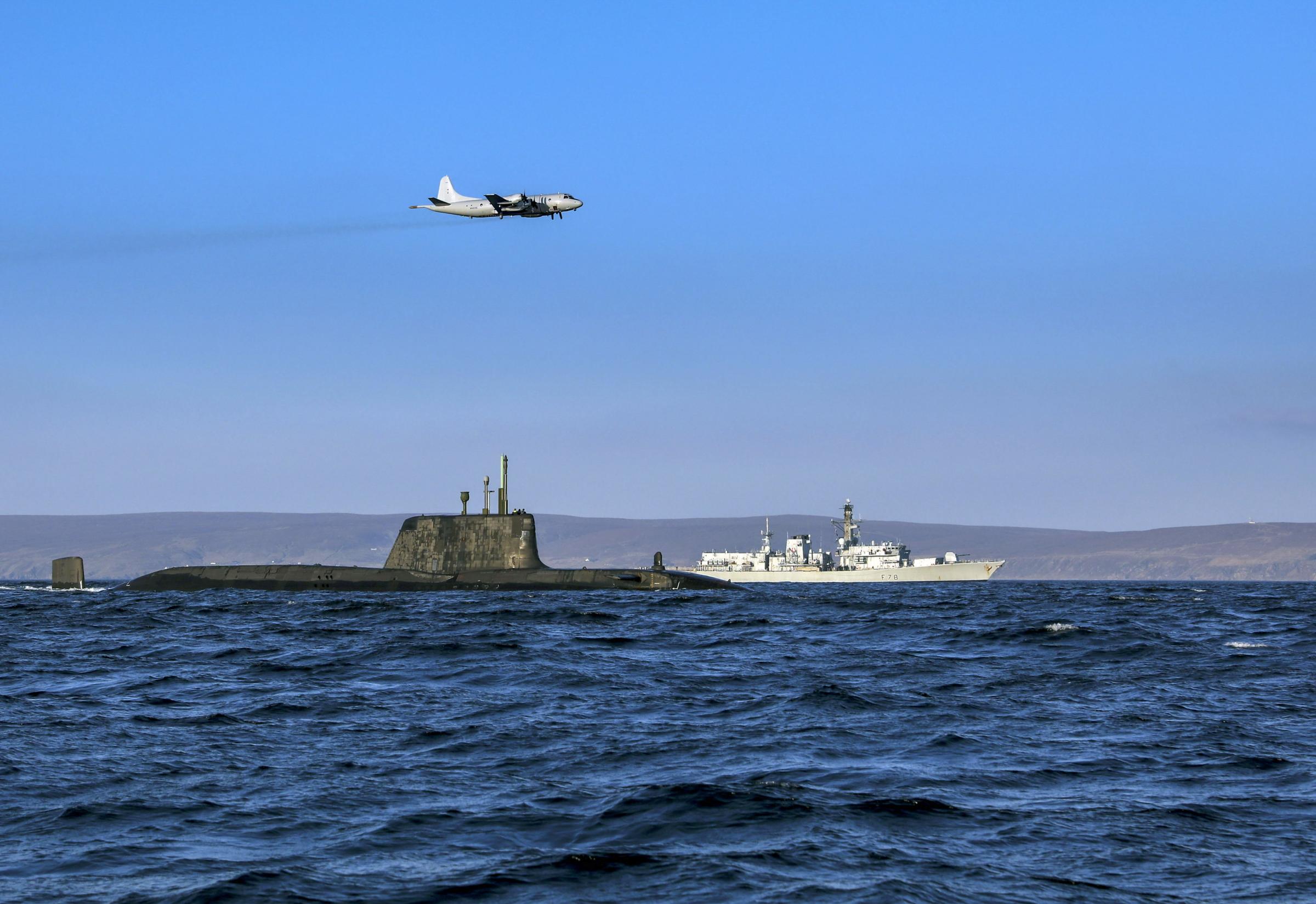 An Astute class nuclear submarine in company with the Type 23 frigate HMS Kent being over flown by a German Navy P3 maritime patrol aircraft during a previous NATO Joint Warrior exercise
