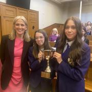 Well done: Ruth Charteris, KC, Solicitor General for Scotland, presented the winning trophy to third-year students Beth Dalrymple and Katie Orr of St Peter the Apostle High School in Clydebank in Parliament House, Edinburgh