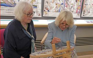 Great Tapestry of Scotland stitcher coordinator Dorie Wilke (left) watches Queen Camilla work on a commemorative tapestry during her visit to The Great Tapestry of Scotland visitor centre in Galashiels