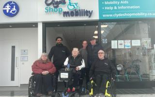 Board members Jackie and Margaret Maceira alongside two staff members at Clyde Shopmobility and service user Sadie Cochrane and her husband Sandy